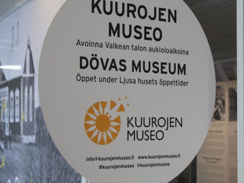 Ovessa valkoinen iso tarra, jossa lukee Kuurojen museo Dövas museum.